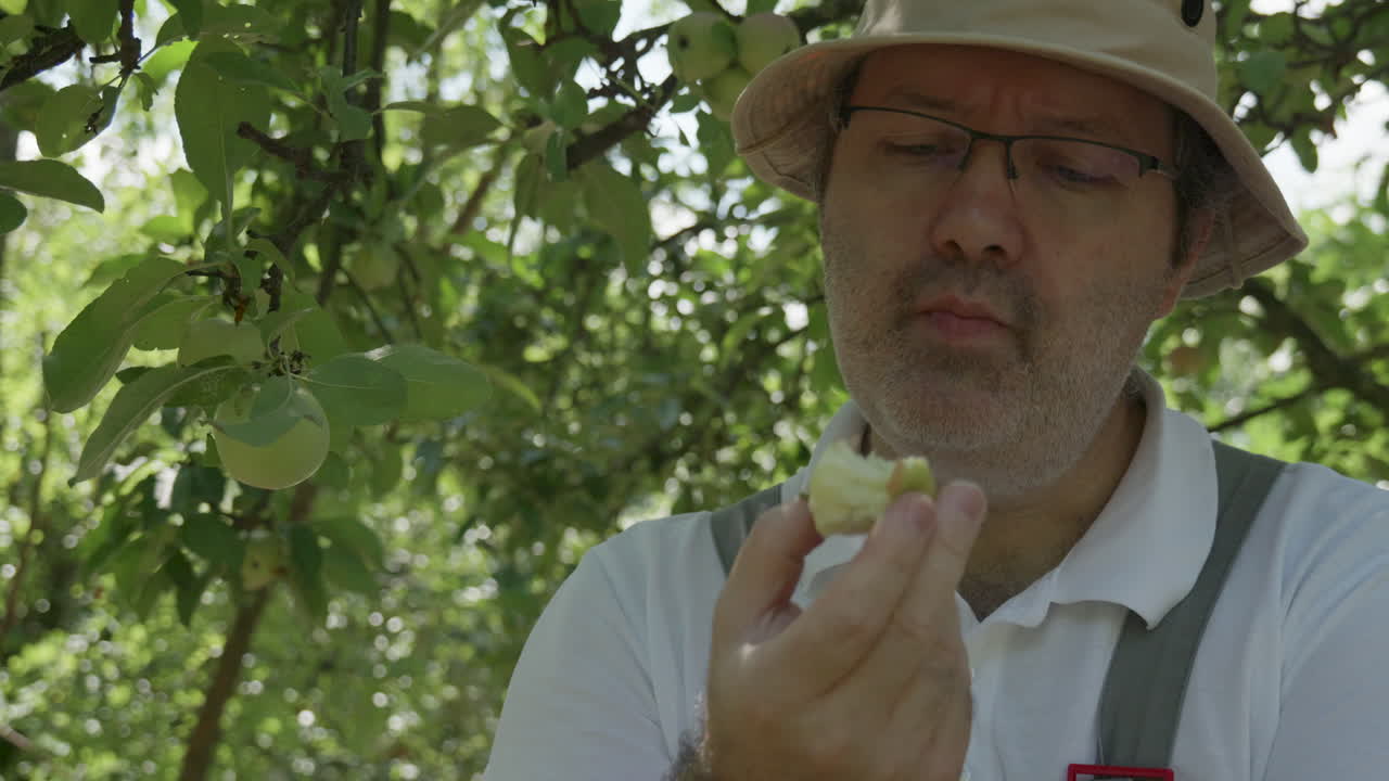 Gardener tasting freshly picked apple