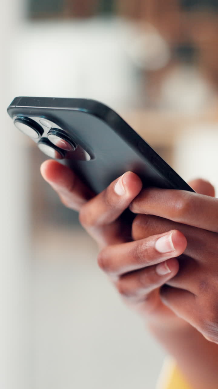 Primo piano di mani che tengono e usano uno smartphone.