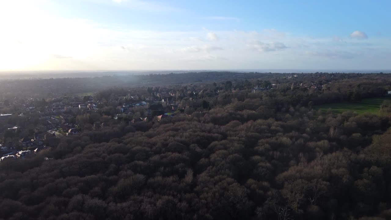 Aerial view of a countryside town surrounded by forest in England
