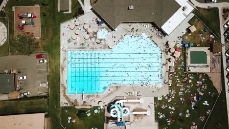 Lowering-drone-shot-directly-above-an-outdoor-public-pool