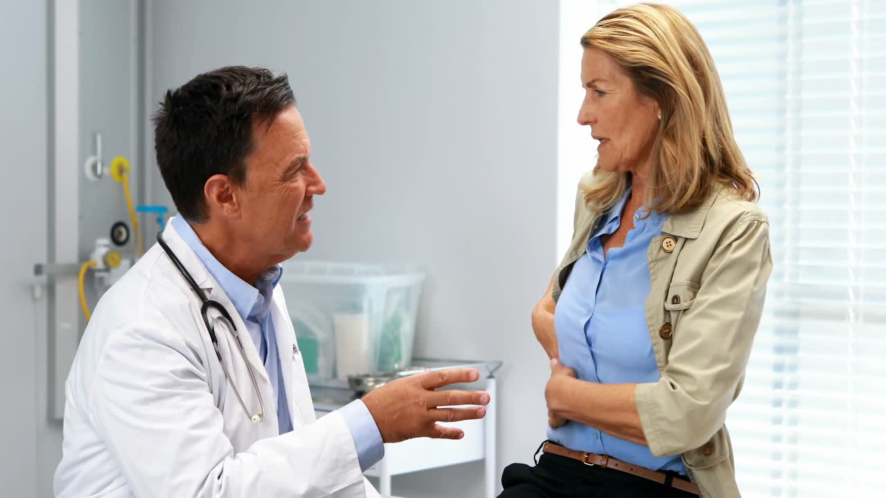 Paziente che soffre di mal di stomaco mentre consulta il medico