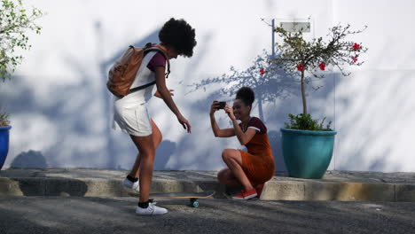 two mixed race women taking picture on street