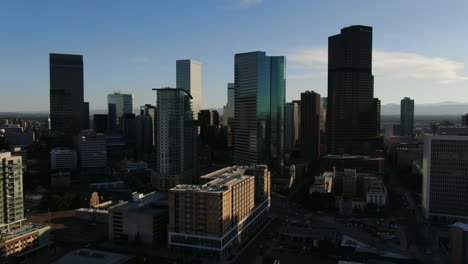 panning drone shot of ultamodern skyline of denver while sunlight is disappearing