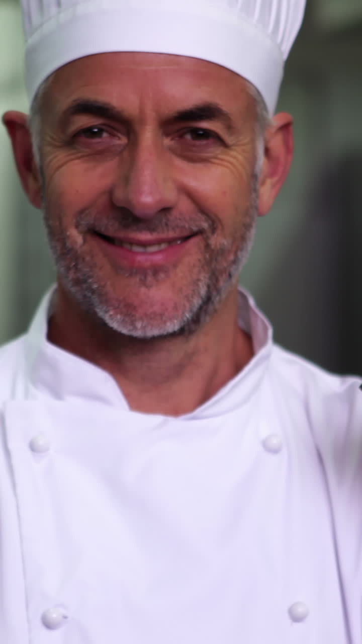 Capo chef che tiene un mestolo e sorride alla telecamera