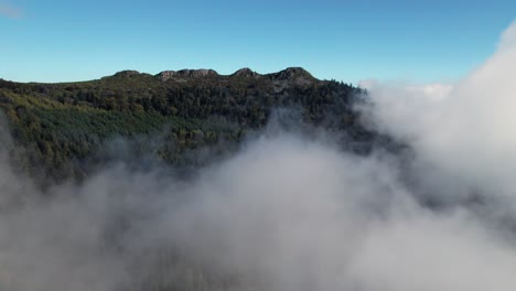 drone shot going forward revealing the pic des 3 dents above the clouds in le pilat natural regional park near saint etienne in loire departement, auvergne rhone alpes region in french countryside