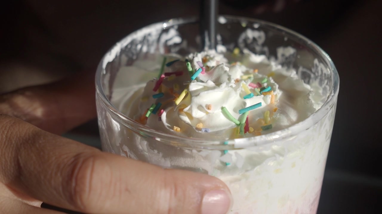 Delicioso batido cubierto con nata montada y virutas de colores