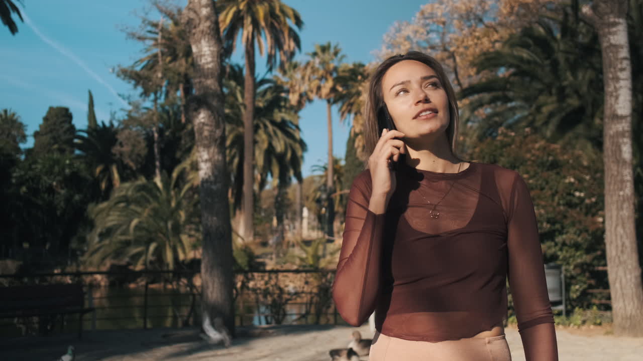 молодая женщина использует смартфон на открытом воздухе.