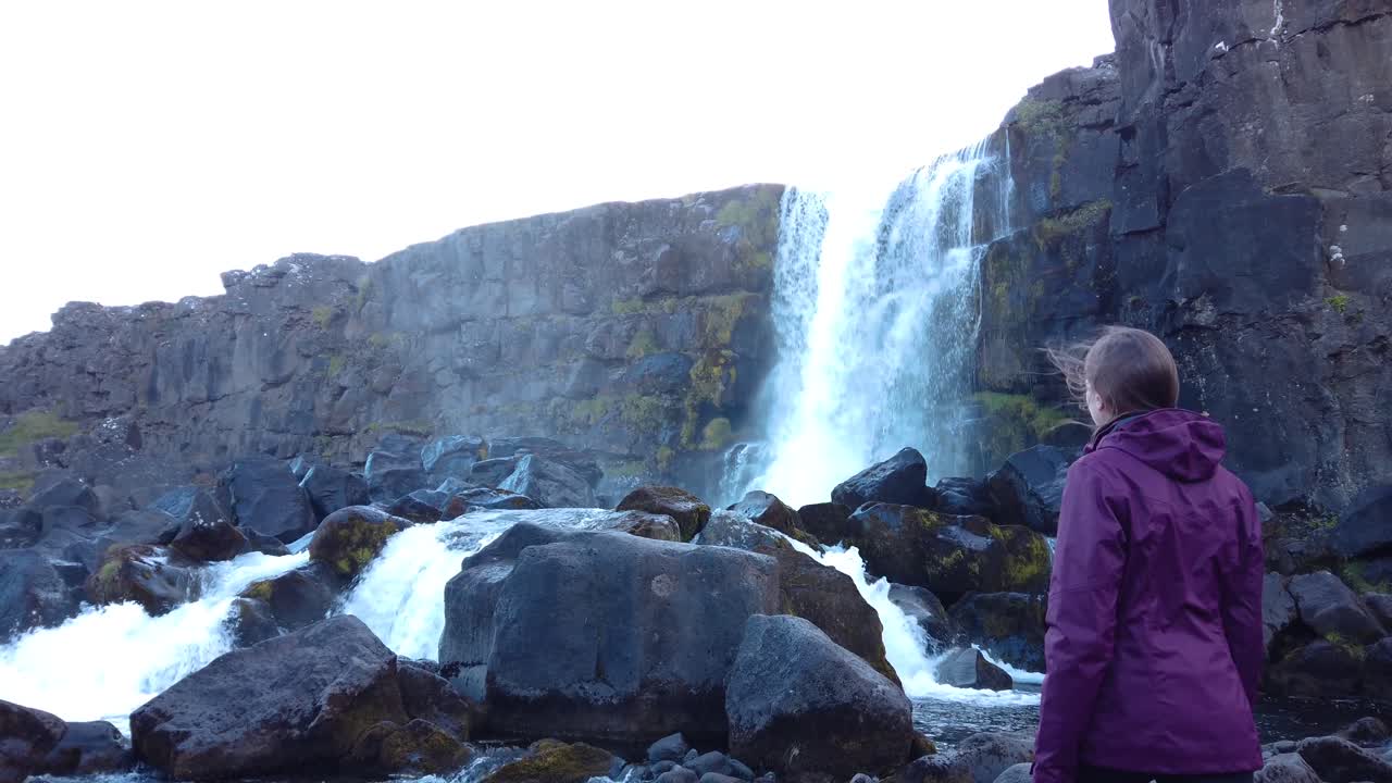 primer plano de mujeres disfrutando de la vista de la cascada en islandia