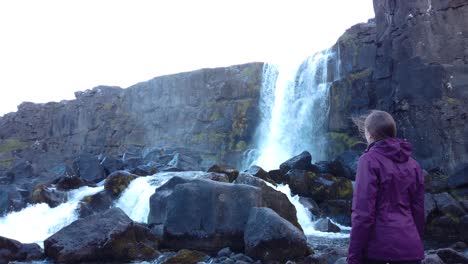 close up shot of women enjoying the view of waterfall in iceland