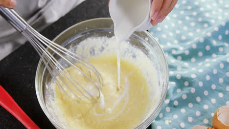 woman adding milk to beaten eggs in a bowl 4k