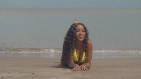 Pan-left-close-up-of-a-young-woman-laying-in-the-sand-of-a-tropical-Caribbean-beach