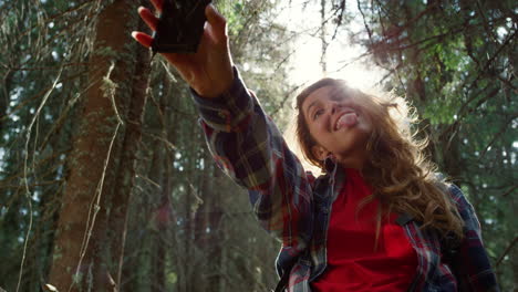 tourist taking selfie on mobile phone in forest