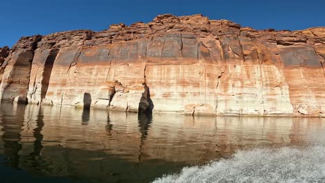 driving jet ski on lake powell view to sandstone cliffs, blue sky, utah