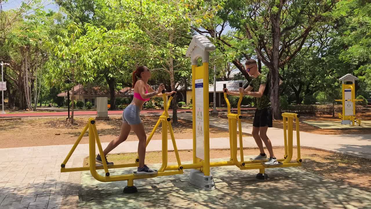 Couple Exercising on a Walking Machine in a Park