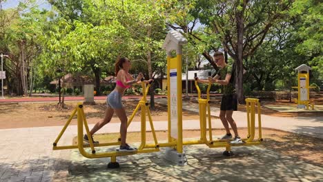 couple exercising on a walking machine in a park