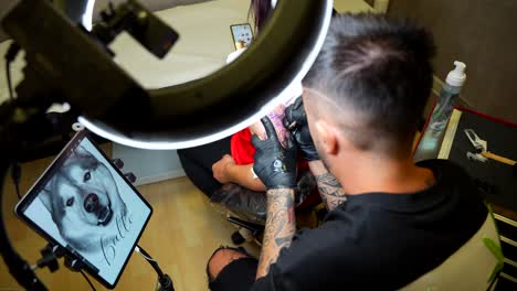 professional tattoo artist applying a shiba inu dog tattoo