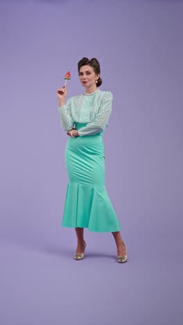 woman in vintage outfit posing with watermelon lollipop