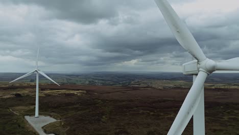 fermer voler par drone vue vidéo aérienne d'un parc éolien et éoliennes tournant dans le vent