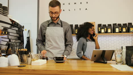 barista masculino caucásico y compañera de trabajo caucásica trabajando en una cafetería moderna