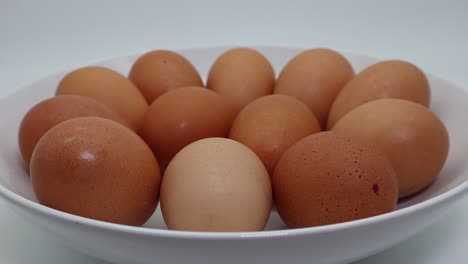 huevos frescos en un plato en pantalla giratoria aislado sobre fondo blanco.