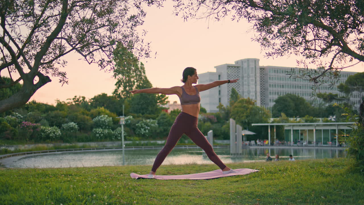 modelo de yoga practicando posición triangular parque de la noche. mujer entrenamiento flexibilidad
