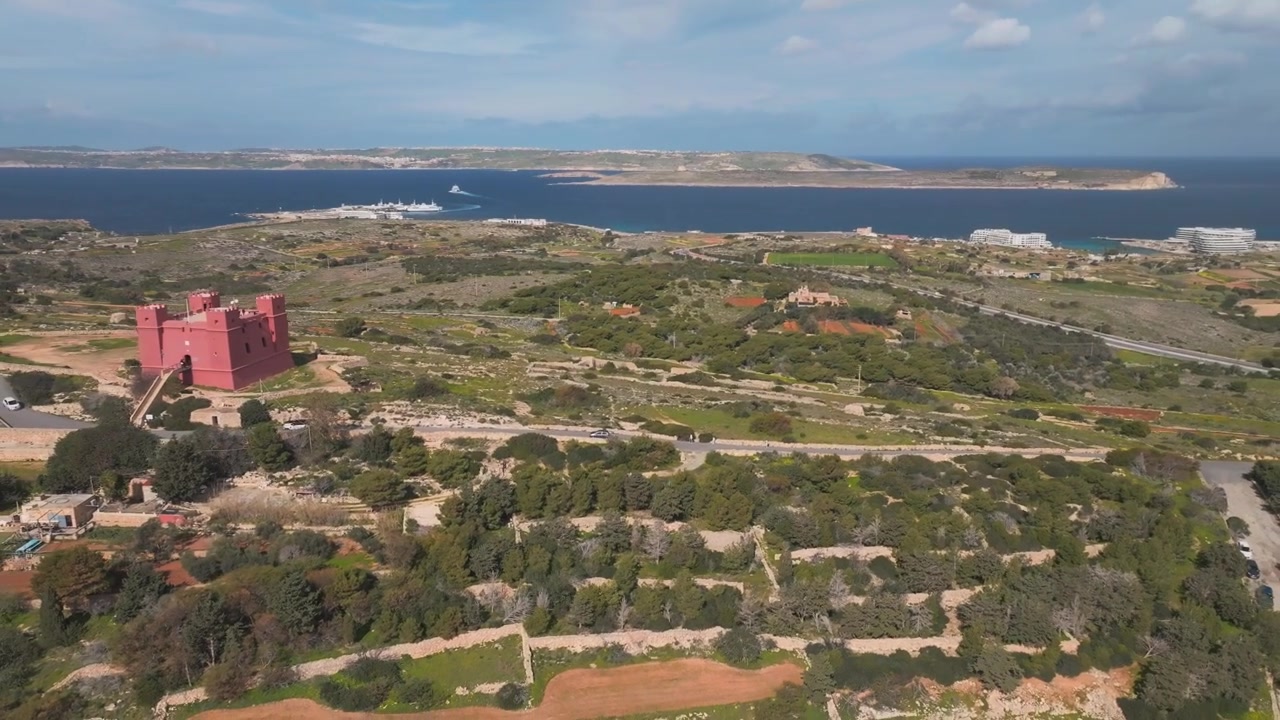 Flygfoto med drönare över Sankta Agathas torn (Röda tornet) i Mellieħa, Malta, solig dag, 4K.