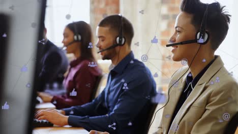 animation of network of digital icons against biracial woman talking on phone headset at office