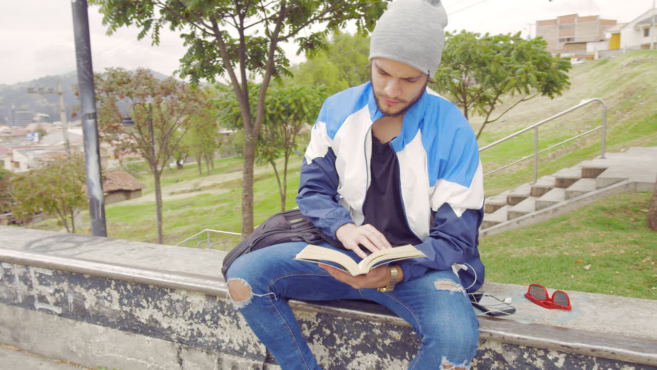 Ragazzino che legge un libro per strada