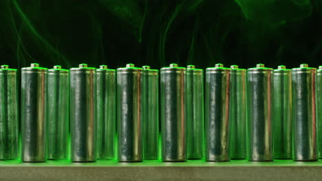 silver batteries aa and aaa in neon light close-up. double-a battery is a standard size single cell cylindrical dry battery. batteries are common in portable electronic devices. an aa battery is composed of a single electrochemical cell that may be either a primary battery or a rechargeable battery.