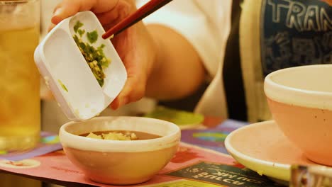 adding ingredients to a bowl of sauce