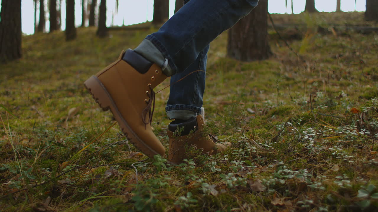 hombre camina a lo largo de las montañas a la cima. turista en botas que va a lo largo de la carretera de piedra en el fondo un hermoso paisaje. concepto de viaje personas activas en el camino a la victoria avanzan de cerca. alta calidad 4k metraje