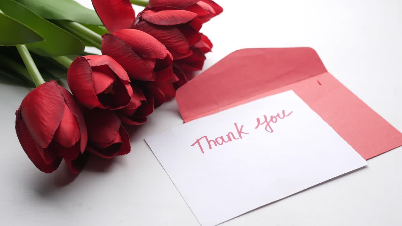 tulipanes rojos y una tarjeta de agradecimiento
