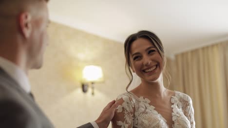 Newlyweds-young-caucasian-bride-and-groom-first-meeting-at-wedding-day,-making-a-kiss-indoors