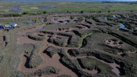 Eerie-Abandoned-Shipwrecked-Boat-Stuck-in-Mud-of-Blackwater-River,-UK,-Aerial