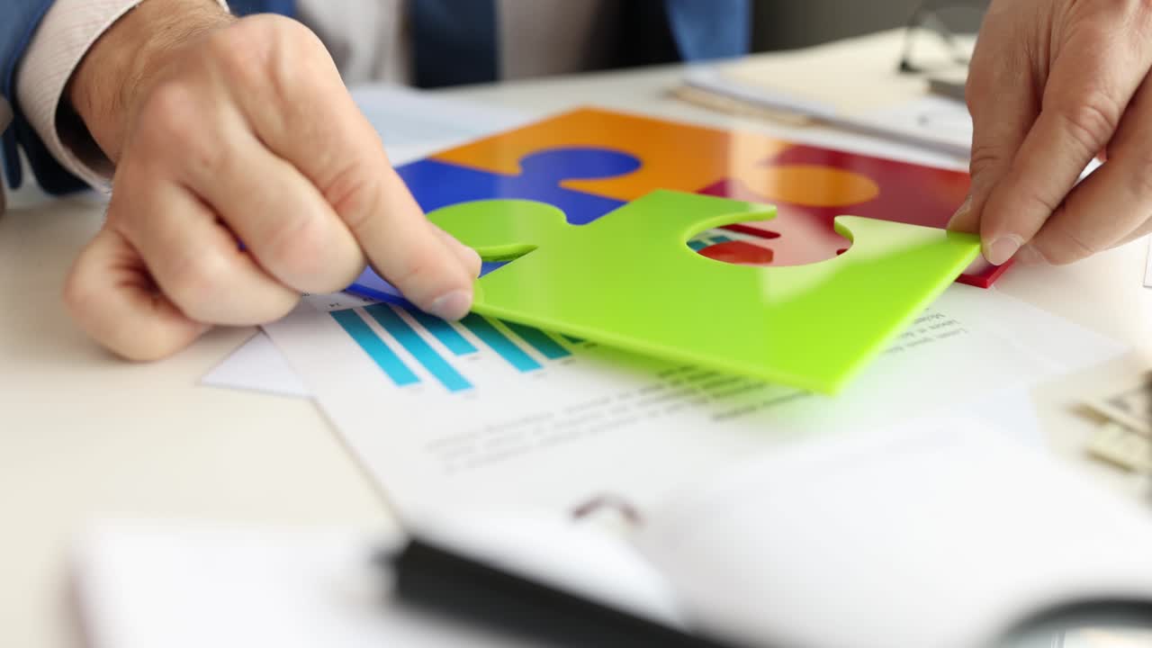 Businessman putting last colorful piece of puzzle on table 4k movie
