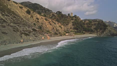 Vista-Aérea-De-La-Costa-De-Nerja,-Al-Sur-De-España,-Moviéndose-Hacia-Atrás-Y-Panorámica-De-Izquierda-A-Derecha