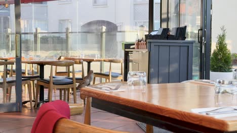 a serene restaurant setting in auckland, new zealand, featuring wooden tables, chairs, and soft natural lighting