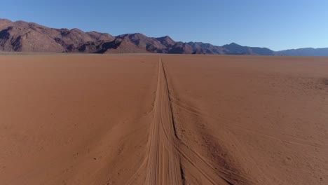 aerial view of safari vehicle driving through the famous fairy circles of namibia