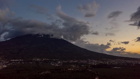 aerial, drone hyperlapse flying towards an active volcano in guatemala during a cloudy beautiful sunset in 4k