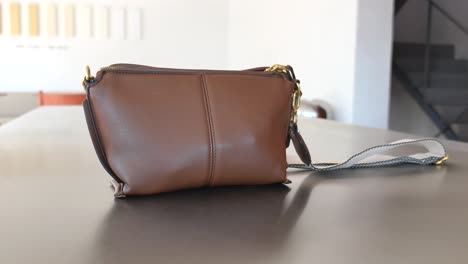 indoor scenes featuring a brown handbag on a table and an empty modern room