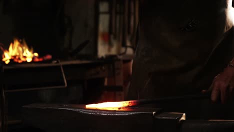 mid-section of blacksmith working on a iron rod