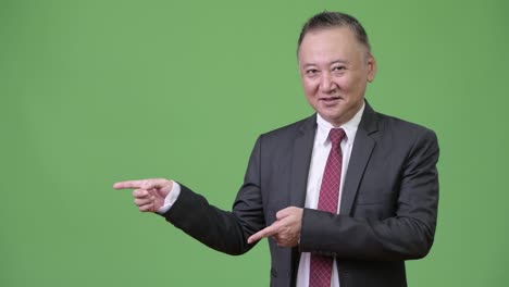 mature japanese businessman showing something