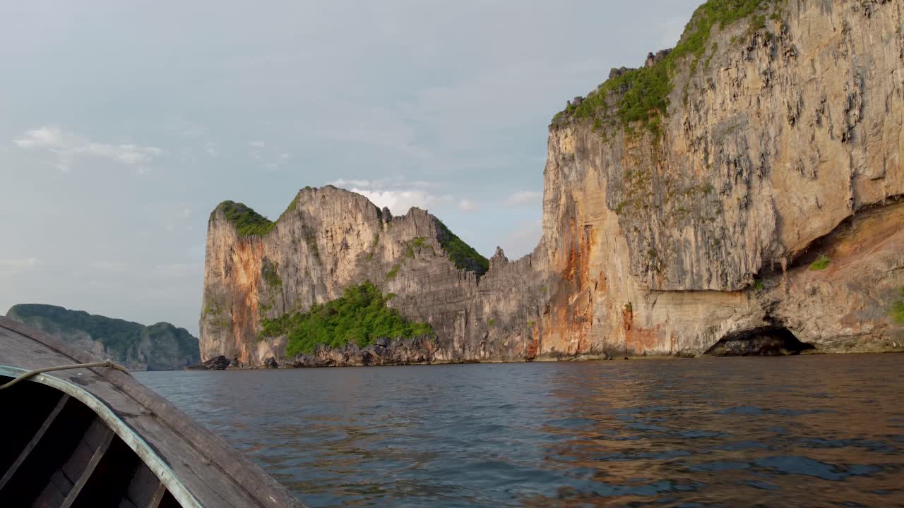 pov vista desde el barco de cola larga mientras navega a lo largo de los acantilados de la isla de la bahía maya - koh phi phi, isla de krabi, tailandia