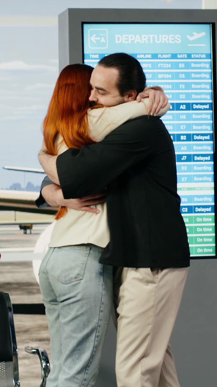 Video Vertical: Pareja joven reuniéndose en la terminal del aeropuerto después de una relación a distancia