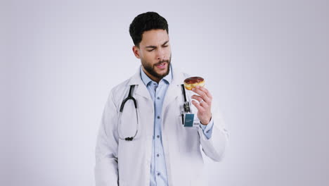 Doctor,-thumbs-down-and-donut-in-studio-for-food