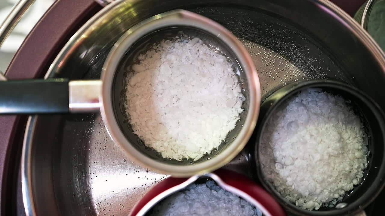 Hand made candles production, melting wax in pots