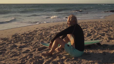 senior man sitting on the sand at the beach