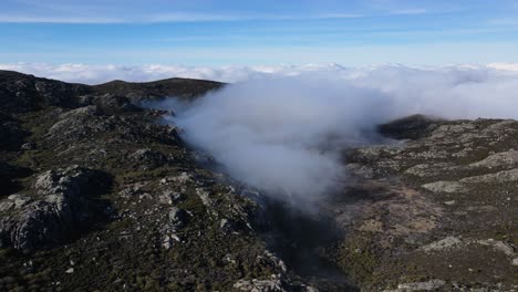vista aérea de un hermoso valle lleno de nubes en lo alto de la montaña en un día soleado y brillante