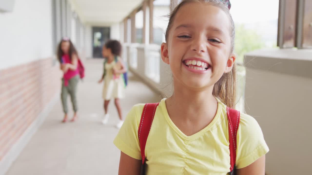 video de una chica caucásica feliz de pie en el pasillo de la escuela