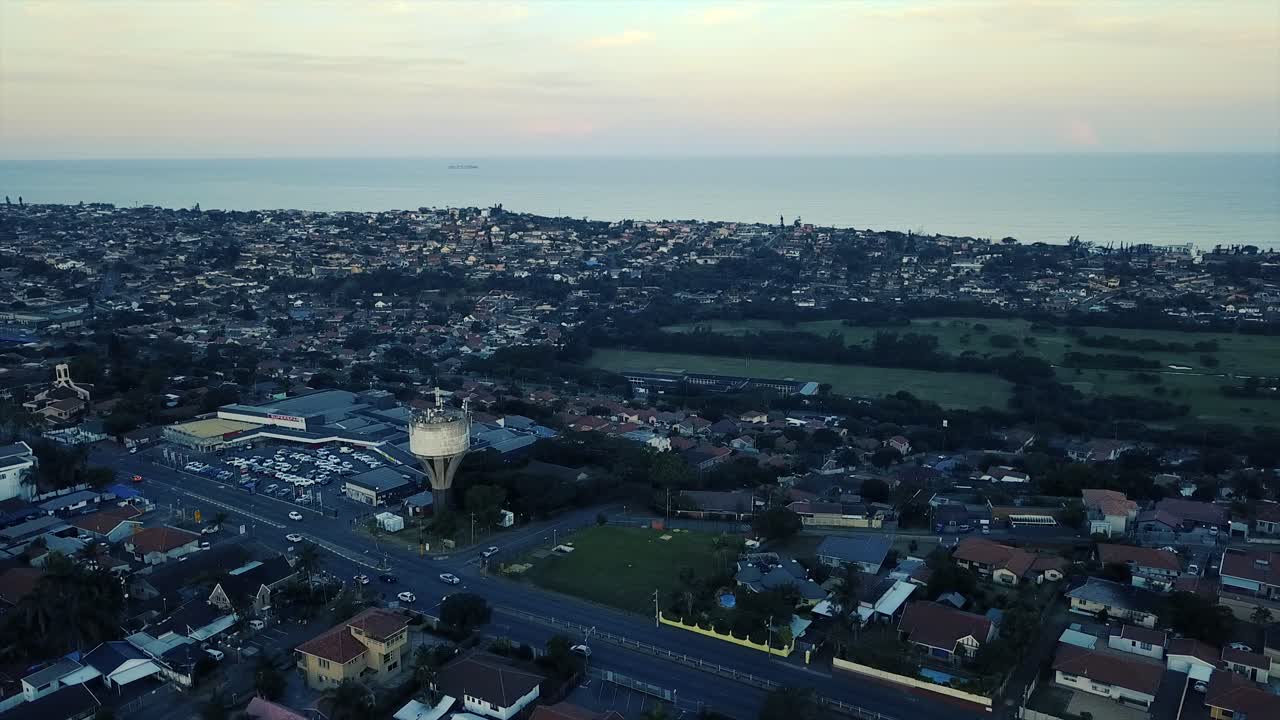급수탑 쇼핑 센터와 푸른 잔디 공원이 있는 골프 코스가 내려다보이는 이동 차량이 있는 도로가 있는 주거용 주택의 드론에서 촬영한 항공 영상